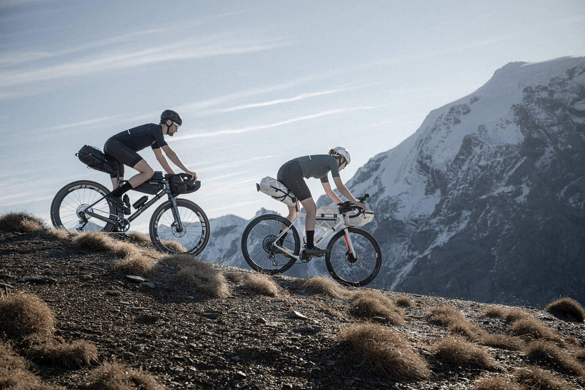 Dwoje rowerzystów z torbami bikepackingowymi Cyclite w górach